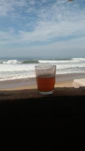 einen Drink in einem Glas am Strand in der Unterkunft Raha Cave Said in Douaïra