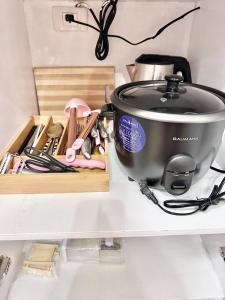 a pot on a shelf next to a box of kitchen utensils at Doms Ryokan in Avida Aspira With Wifi and Netflix in Cagayan de Oro