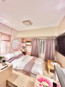 ein Schlafzimmer mit einem großen Bett und einem Schreibtisch in der Unterkunft Doms Ryokan in Avida Aspira With Wifi and Netflix in Cagayan de Oro
