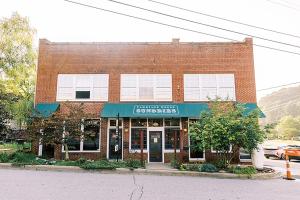 un edificio de ladrillo en una esquina con un edificio en The NuWray Hotel & Carriage House, en Burnsville