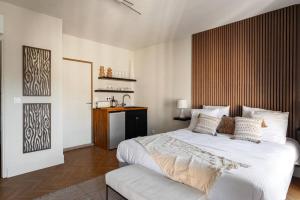 1 dormitorio con 1 cama blanca grande y cabecero de madera en L'Évêché/ Clim/ Vue/ Confort, en Carcassonne