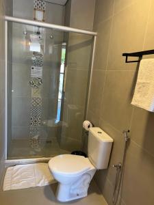 a bathroom with a toilet and a shower at Rogai Hotel Pousada in Aparecida