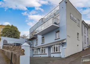 um edifício branco com uma varanda ao lado em Anzac em Brixham