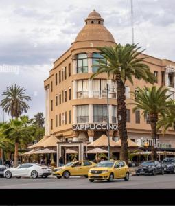 een gebouw waar auto's voor geparkeerd staan bij Superbe appartement de luxe a l'hivernage marrakech in Marrakesh