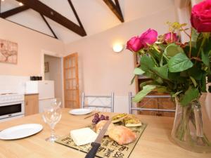 a table with a vase of roses and a plate of food at 1 bed in Burnham-on-Sea ALPAD in Highbridge