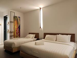 T+ PREMIUM HOTEL في ألور سيتار: غرفه فندقيه سريرين في غرفه