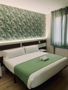 a bedroom with a large bed with a green blanket at Hostal Abadia Madrid in Madrid