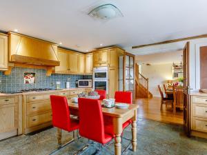 eine Küche mit einem Holztisch und roten Stühlen in der Unterkunft 5 Bed in Bampton GRACI in Oakford