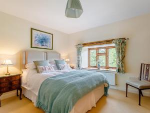 sypialnia z dużym łóżkiem i oknem w obiekcie 5 Bed in Bampton GRACI w mieście Oakford
