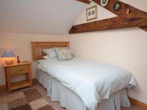 a bedroom with a white bed with a wooden headboard at 2 Bed in Bideford HIFOX in Shebbear