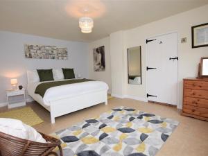 a bedroom with a white bed and a rug at 2 Bed in Bampton SHAYN in Huntsham