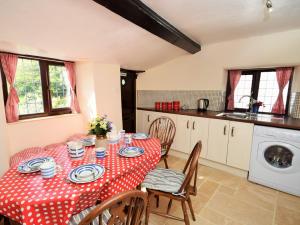 a kitchen with a table with a red and white table cloth at 3 Bed in Bude PORTH in Morwenstow
