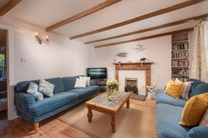 a living room with blue couches and a fireplace at Roseneath in St. Agnes