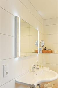 a white bathroom with a sink and a mirror at Pension Olympia in Oetz