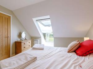 a bedroom with a large white bed with red pillows at 2 Bed in Sturminster Newton 88265 in Fiddleford