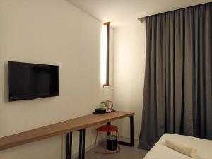 a hotel room with a tv on the wall and a stool at T+ PREMIUM HOTEL in Alor Setar