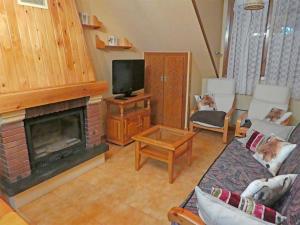 ein Wohnzimmer mit einem Kamin und einem TV in der Unterkunft Apartamentos Villanua 3000 in Villanúa