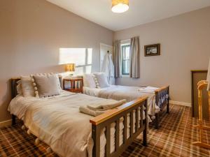a bedroom with two beds and a window at 2 Bed in Ardgay 88798 in Culrain