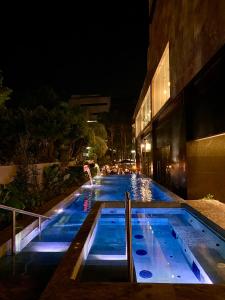 una piscina di notte accanto a un edificio di Grand Fiesta Americana Guadalajara Country Club a Guadalajara