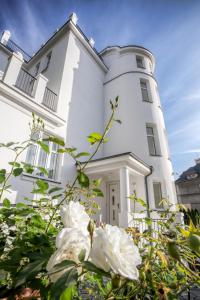 a white house with flowers in front of it at Apartments Villa Whitehouse in Ostrava