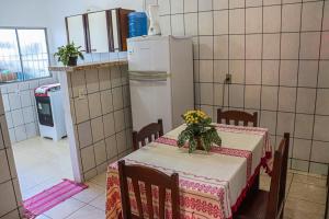 a small kitchen with a table and a refrigerator at Aconchegante e lindo Apartamento da Graça perto do aeroporto e melhor churrascaria in Porto Seguro