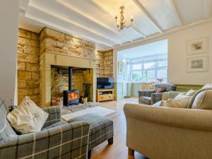 a living room with couches and a stone fireplace at 2 bed property in Rothbury Northumberland 89502 in Thropton