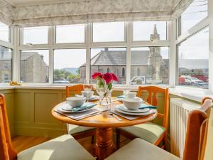 una mesa con un jarrón de flores en una habitación con ventanas en 2 bed property in Rothbury Northumberland 89502 en Thropton
