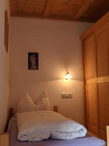 een bed in een slaapkamer met een licht aan de muur bij Appartement Egart 2 in Resia