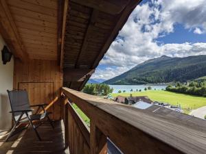a balcony with a view of a lake and mountains at Mansardenwohnung Egart in Resia