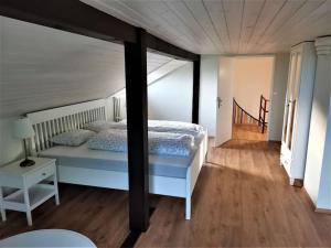 Schlafzimmer mit einem Bett und Holzboden in der Unterkunft Haus 44 in Liběšice