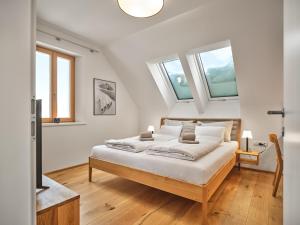1 Schlafzimmer mit einem großen Bett und 2 Fenstern in der Unterkunft Mountain Lovers Three by AA Holiday Homes in Tauplitz