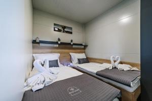 2 Betten in einem Zimmer mit Handtüchern darauf in der Unterkunft Glamping Lucky House in Gradac
