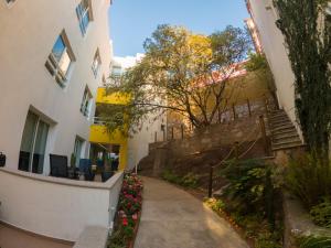 uma passagem entre dois edifícios com flores em La Cañada em Guanajuato