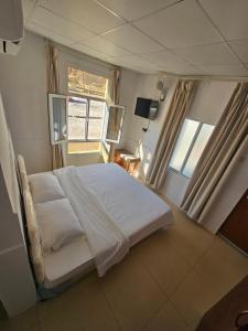 - une chambre avec un lit blanc et une fenêtre dans l'établissement Wadi ashab chalets شاليهات وادي الشاب, à Sour