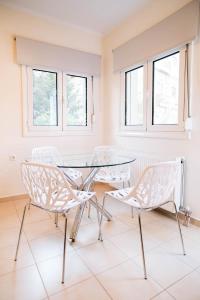 una mesa y sillas en una habitación con ventanas en Ioannina City Relax Apartment, en Ioannina