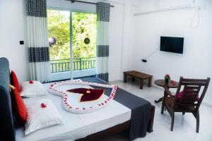 Hotel Sapid Luck Yala Safari في تيساماهاراما: غرفة نوم عليها سرير مع كيكة