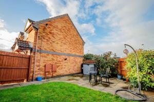 a backyard with a brick building and a fence at Guest Homes - Chichester Close Flat in Hereford