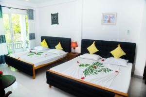 2 letti in una camera con pareti bianche di Hotel Sapid Luck Yala Safari a Tissamaharama