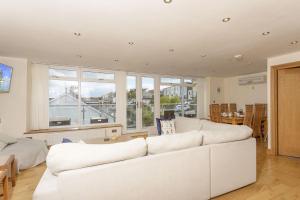 uma sala de estar com mobiliário branco e uma grande janela em Anzac House em Brixham
