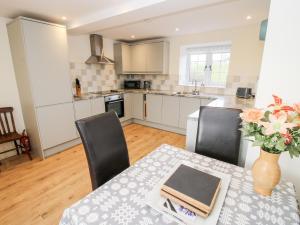 a kitchen with a table with a vase of flowers at Ty Gwyn in Welshpool