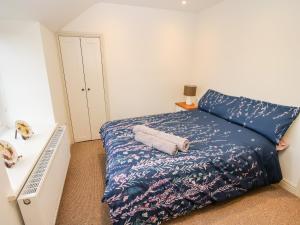 a bedroom with a bed with a blue comforter at Ty Gwyn in Welshpool