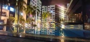 a building with palm trees and a swimming pool at night at Ipoh Water Park(14pax) Homestay@HopeStay in Ipoh