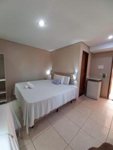 1 dormitorio con 1 cama blanca grande en una habitación en Pousada Badejo en Japaratinga
