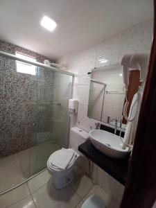 y baño con aseo, lavabo y ducha. en Pousada Badejo, en Japaratinga