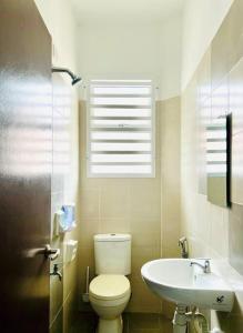Cozy Scandi home @ Balok! في Kampung Saberang Balok: حمام مع مرحاض ومغسلة ونافذة