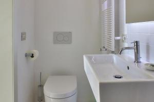 Baño blanco con lavabo y aseo en Il Giardino Segreto, en Sacile