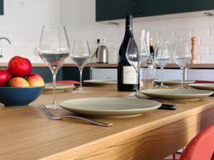 una mesa con copas de vino y manzanas. en La Casa Calot en Angers