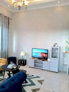 a living room with a blue couch and a flat screen tv at Spacious, Scenic & Homely Loft in Kigali
