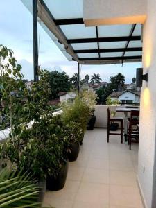 a patio with potted plants and a table on a balcony at Spacious, Scenic & Homely Loft in Kigali
