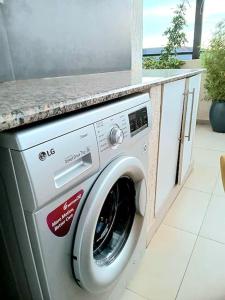 a washing machine in a kitchen with a counter at Spacious, Scenic & Homely Loft in Kigali
